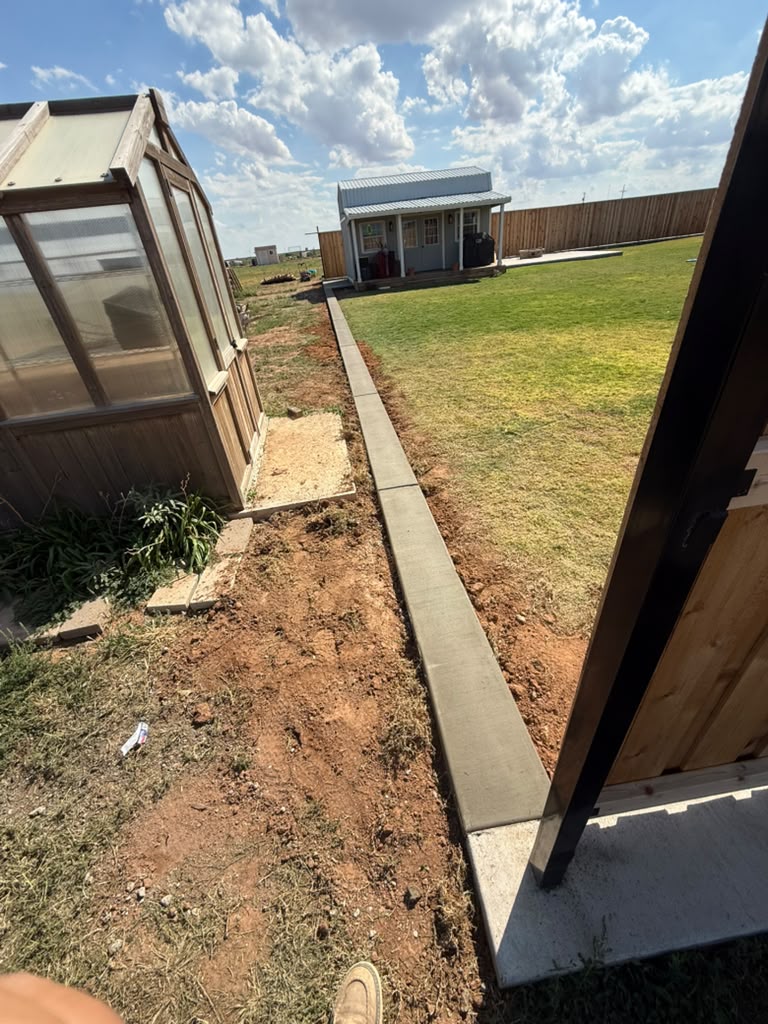 Finished concrete border along the lawn with control joints.