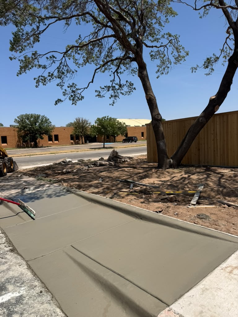 New driveway apron with a formed curb along its edge.