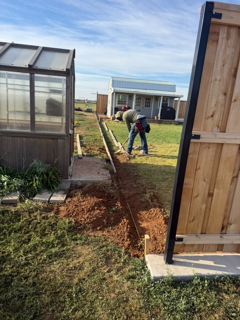 Crew excavating and setting forms for a concrete garden border.