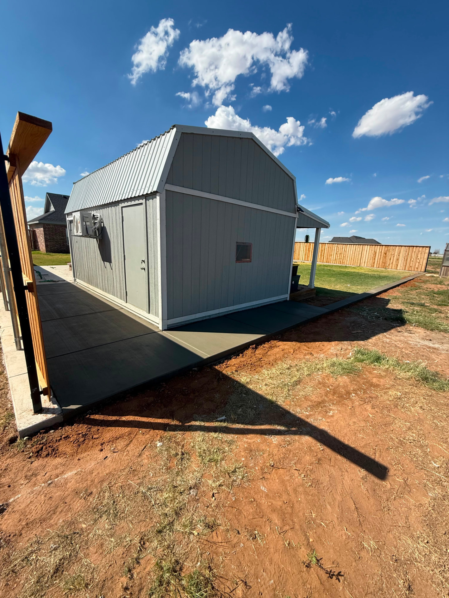 Pad and wraparound slab poured around a backyard building.
