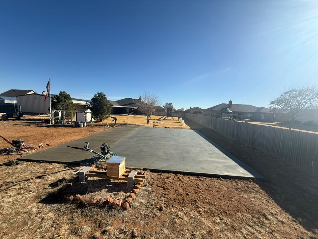 Freshly finished concrete slab with finishing equipment alongside the pour.