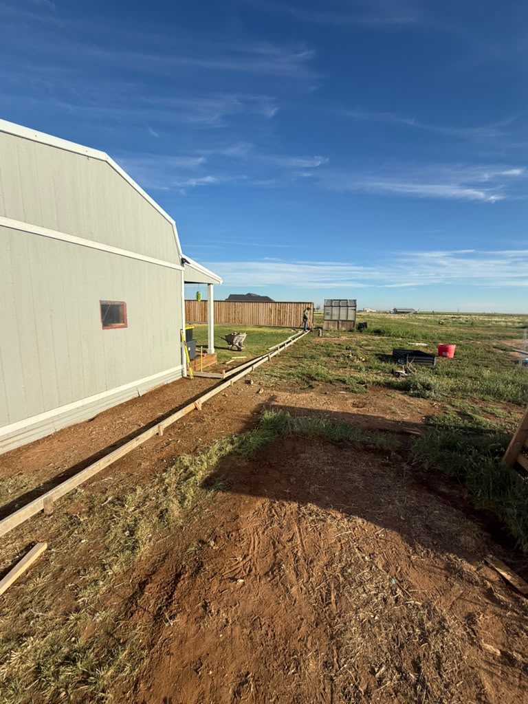 Long curb forms set beside a shop building before the pour.