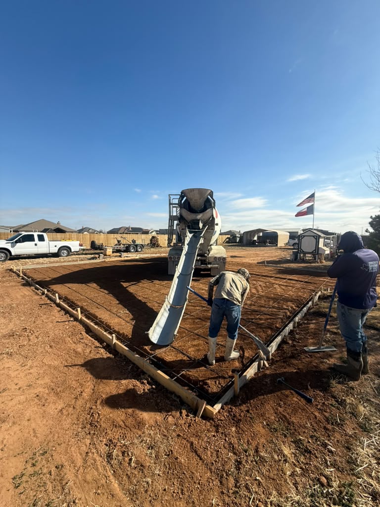 Crew placing concrete into a formed slab with a rebar grid.