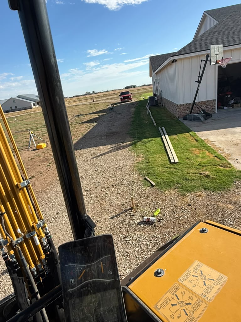 Curb layout marked along the lawn beside the garage before excavation and pouring.